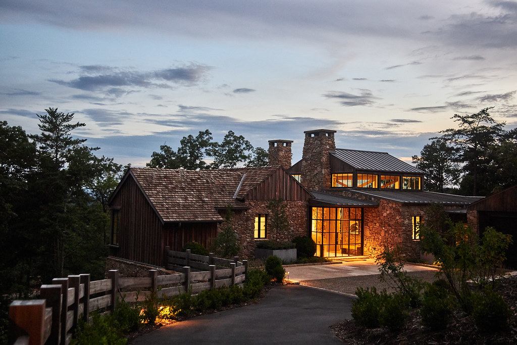 luxurious cabin lit against a backdrop of forest and sky