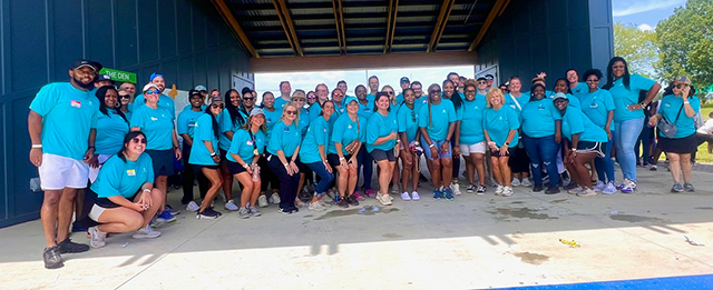 employees posing in amphitheater on a sunny day